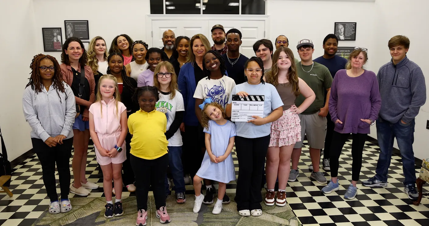 Students of all ages at That's a Wrap Acting Studio in Hattiesburg posing together with a film clapperboard